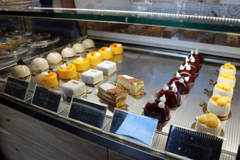 a selection of cakes behind a glass counter in Hiszteria Cremeria