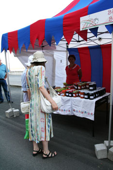 two ladies in hat at a stall selling jams and preserves