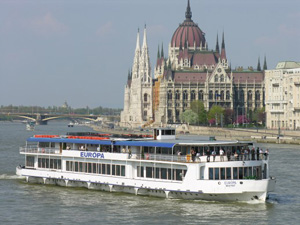 a double decker cruise boat on the Danube at the Parliament