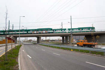 a green Suburban Railway on a flyover