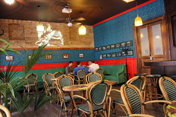 the blue-green interior of the cafe with reed chairs