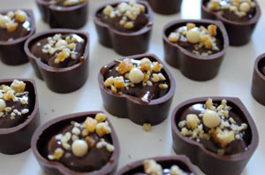 heart-shaped bonbons with ganache filling and nut sprinkles