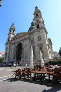 front view of the basilica and part of a cafe terrace on the square
