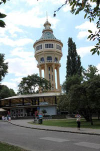the pale yello water tower surrounded with trees