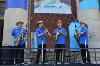 a jazz quartet dressed in blue shirt and wearing a straw hat playing