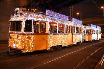 the yellow tram No. 2 with strings of LED light standing at one of its stops