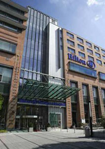 entrance and facade of the hotel with Hilton written in blue