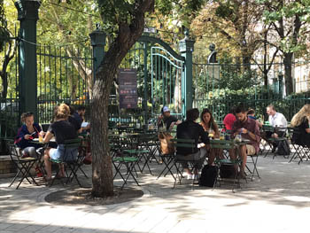 a dozen people sitting at tables on the bar's terrace