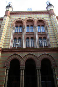 front view of the yellow brick-red arcaded facade, 3 vaulted windows on the first floor