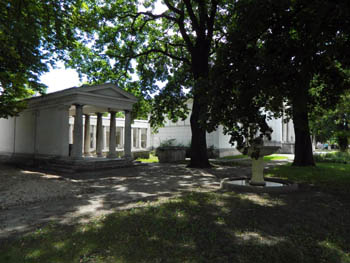 a white colonaded building with tympanum in the museum garden