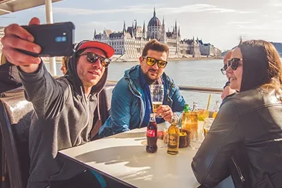 3 mean and a young lady on a booze cruise in Budapest during the day