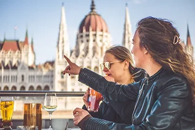 two women with long hair on the open deck of a party boat in Budapest in daylight