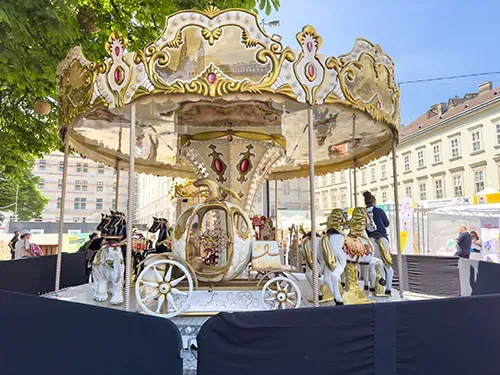 an antique beige merry-go-round in City Hall park on a festival