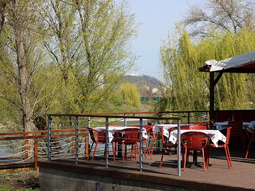 the terrace of Fruska Bistro at Kopaszi dam in April, the Gellért Hill is visible in the distance