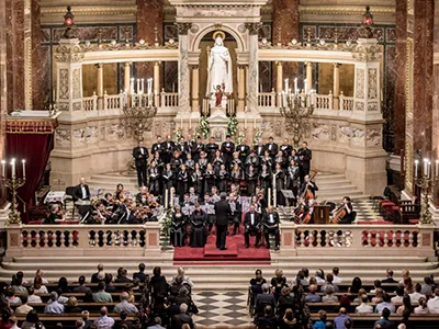 a choir performing in front of the main altar of St. Stephen's Basilica