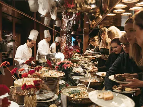 Buffet dinner table with guest selecting food